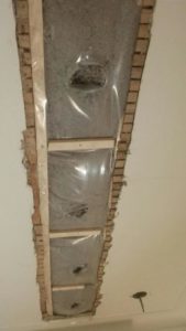 Cellulose blown between floors in a residence through a slot cut in the ceiling.